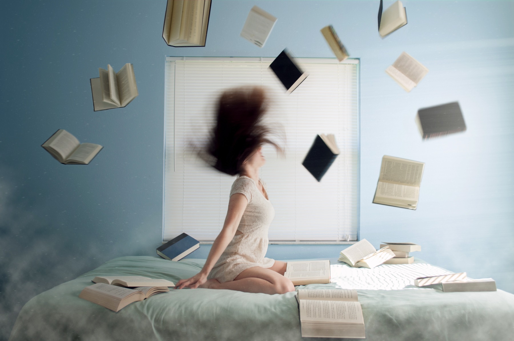 Stressed-out woman throwing books into the air